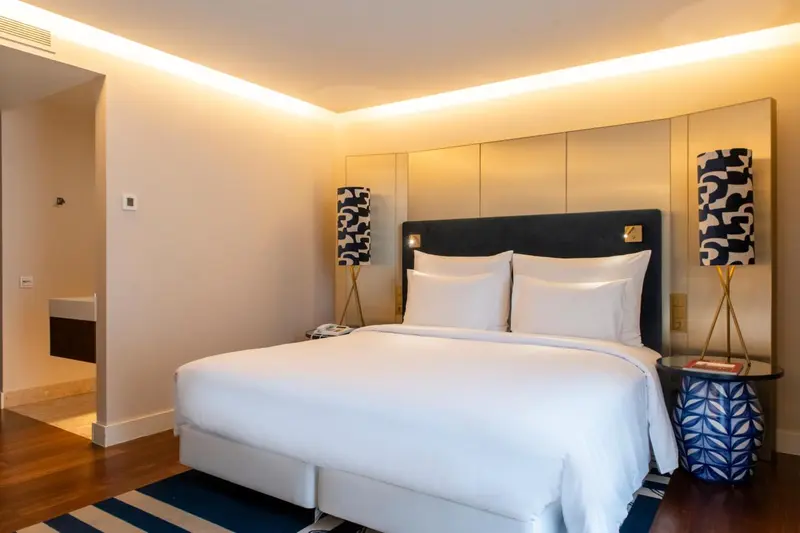 Une chambre lumineuse avec un grand lit recouvert de draps blancs.