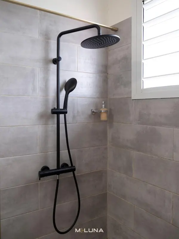 Une douche à l'italienne avec pommeau et douchette.