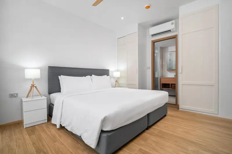 Une chambre lumineuse avec un grand lit et des meubles modernes.