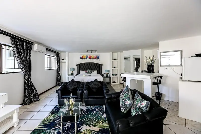 Espace de vie intérieur avec canapés, table basse et lit à baldaquin.