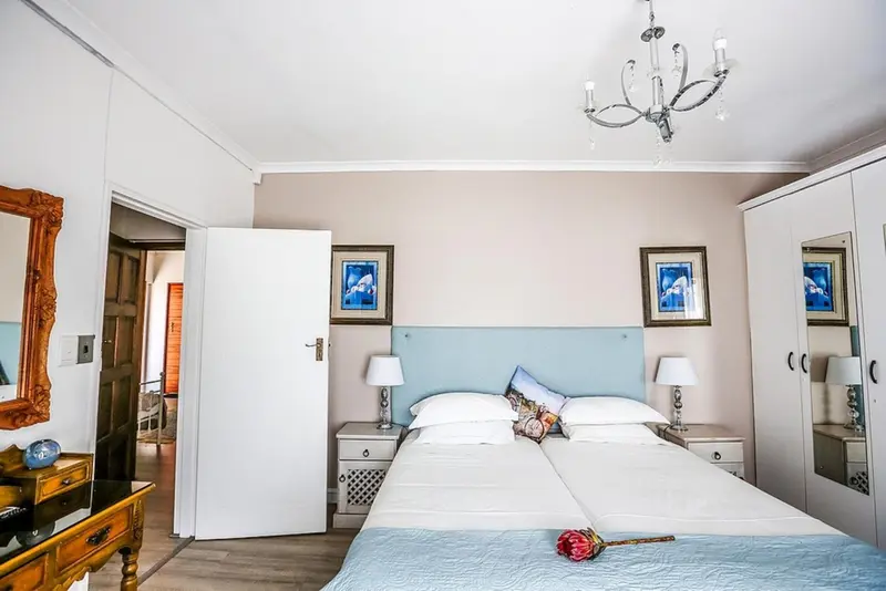 Une chambre lumineuse avec un grand lit et un lustre.