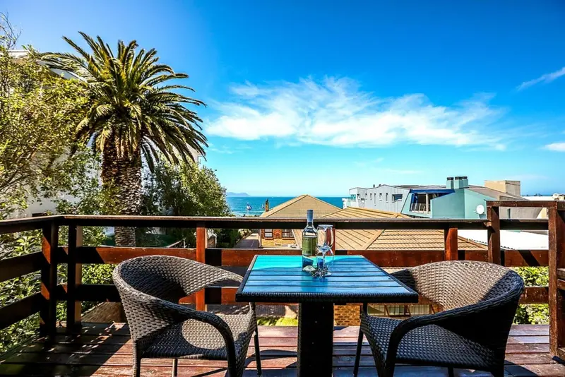 Terrasse avec mobilier de jardin et vue sur la mer.