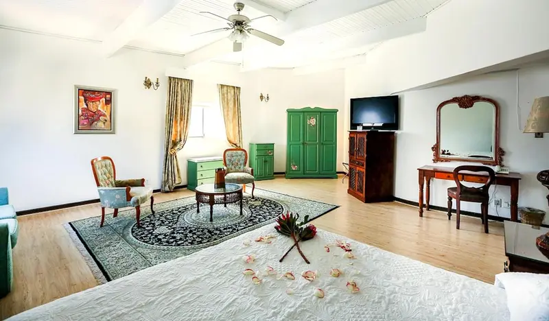 Une chambre lumineuse avec un grand lit et un coin salon.