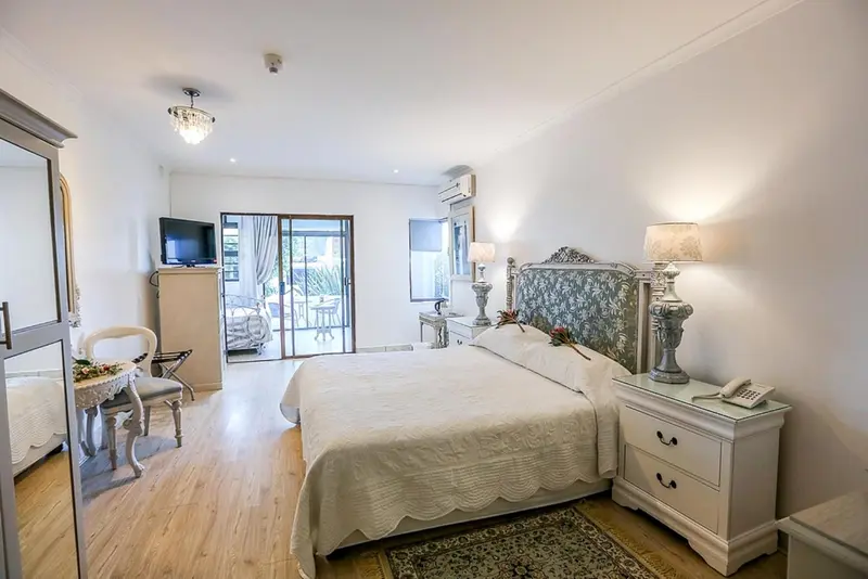 Une chambre lumineuse avec un grand lit et un accès à une terrasse.