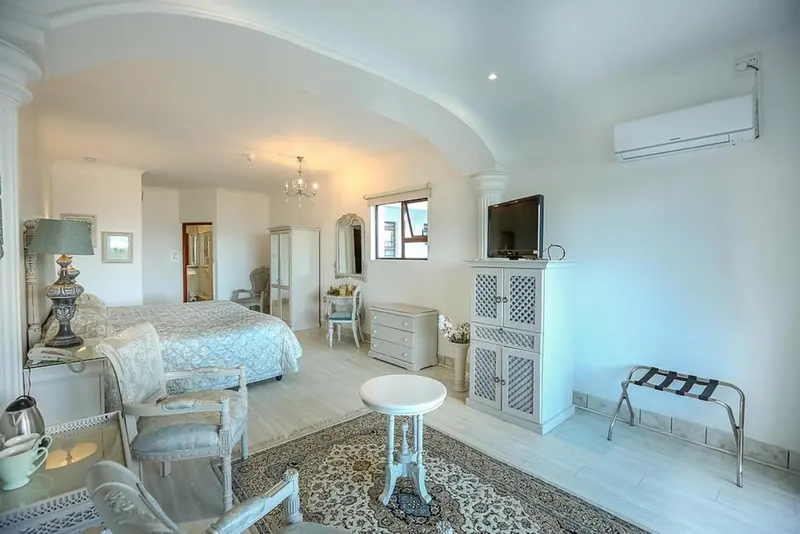 Une chambre lumineuse avec un lit à baldaquin et un mobilier clair.