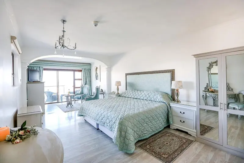 Une chambre lumineuse avec un grand lit et un mobilier clair.