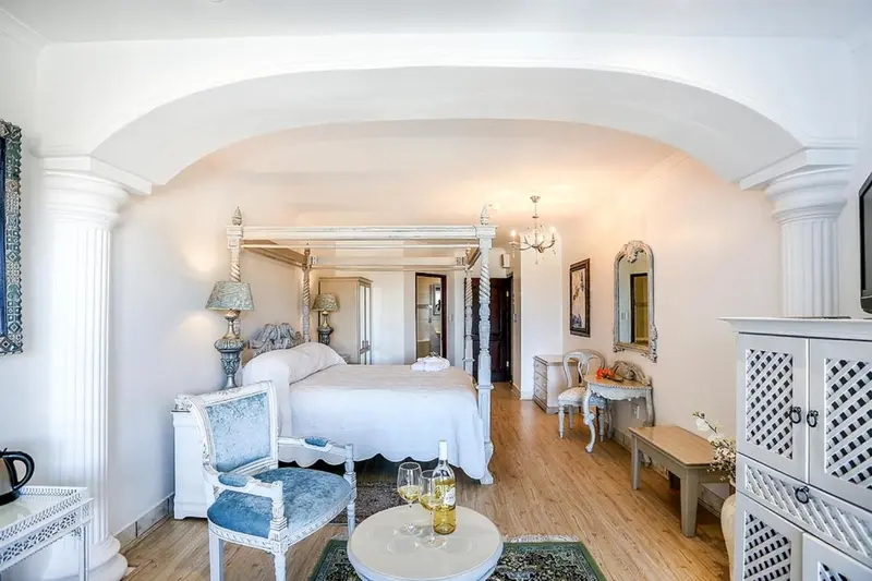 Une chambre lumineuse avec un lit à baldaquin et une décoration classique.