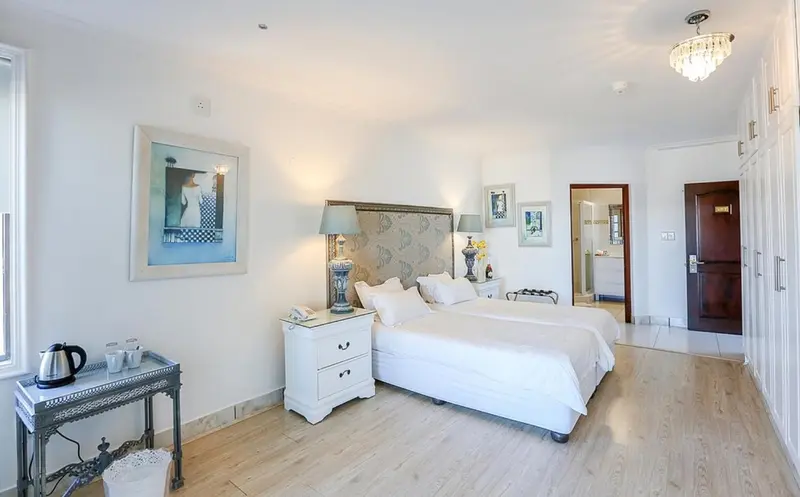 Une chambre lumineuse avec un grand lit et une décoration sobre.