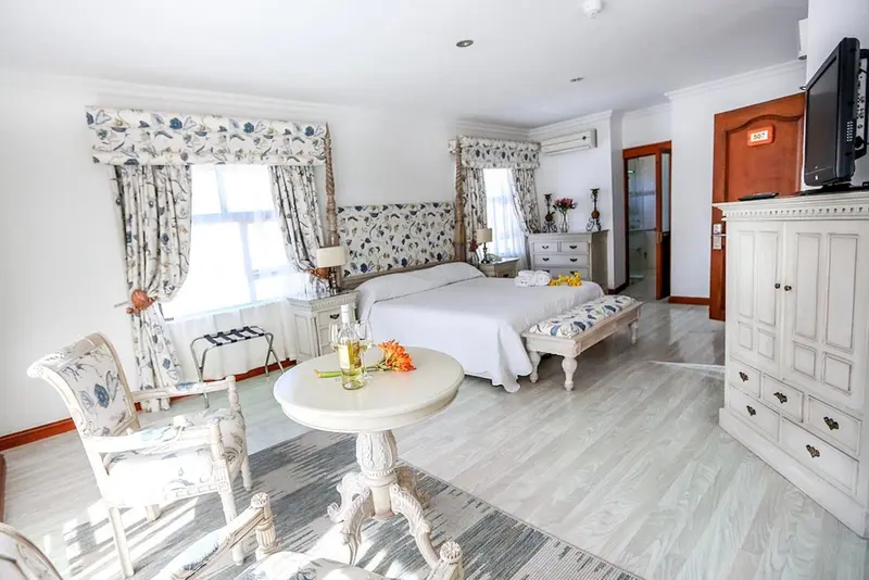 Une chambre lumineuse avec un lit double et un mobilier clair.