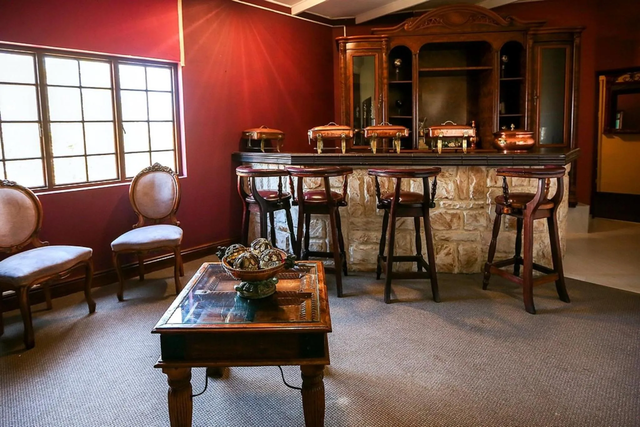 Un bar avec des tabourets et un comptoir en pierre.