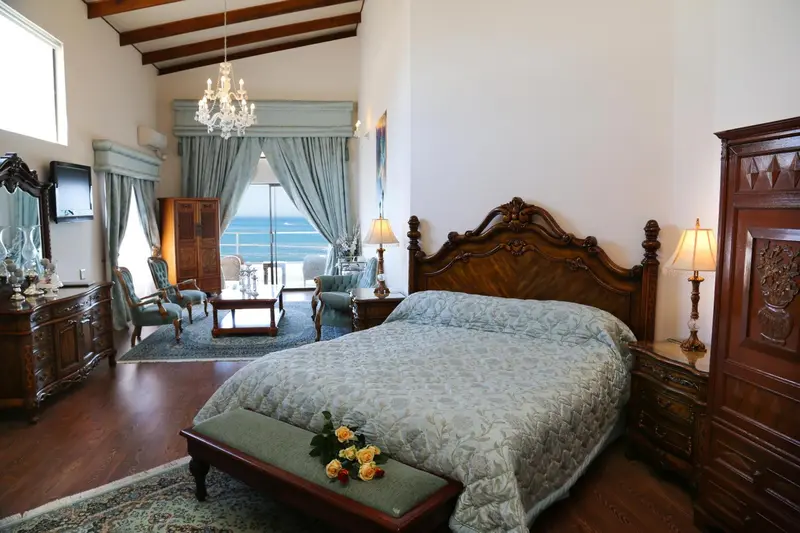 Une chambre spacieuse avec un grand lit et un lustre décoratif.