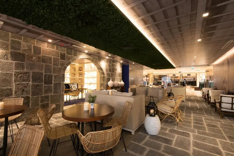 Espace de détente intérieur avec mobilier clair et décorations végétales.