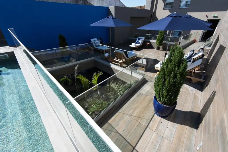 Terrasse aménagée avec piscine et végétation luxuriante.