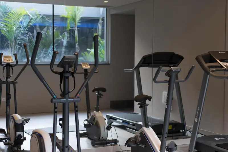 Une salle de sport avec plusieurs appareils de cardio.