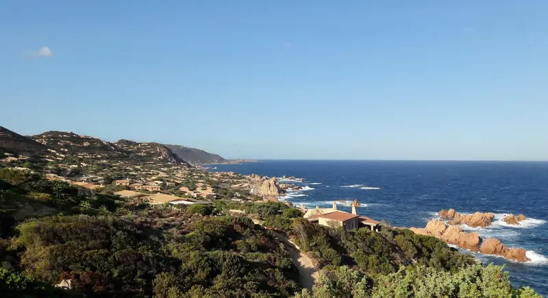 Vue panoramique sur une côte rocheuse et la mer bleue.