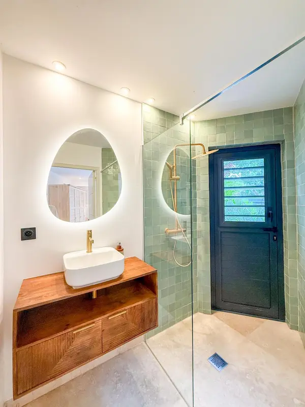 Une salle de bain moderne avec une douche à l'italienne et un lavabo sur meuble.