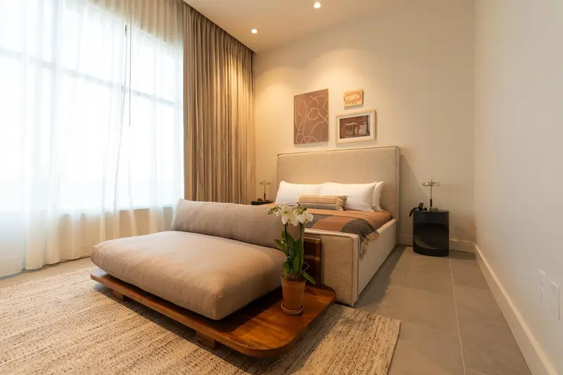 Une chambre lumineuse avec un grand lit et des tableaux décoratifs.