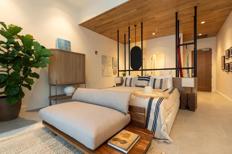 Une chambre lumineuse avec un grand lit et un coin salon.