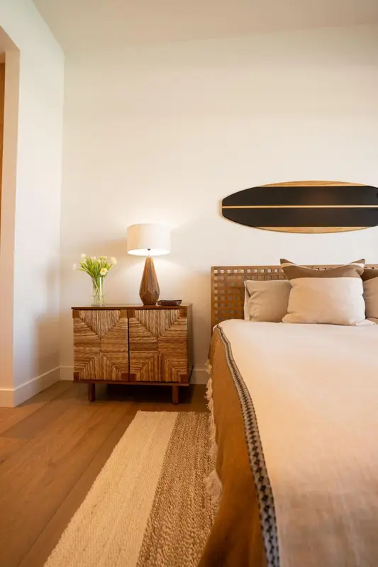 Une chambre lumineuse avec un lit recouvert d'une couverture et une décoration murale.