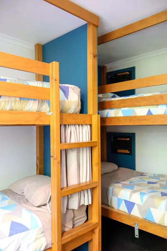 Lits superposés en bois dans une chambre colorée.