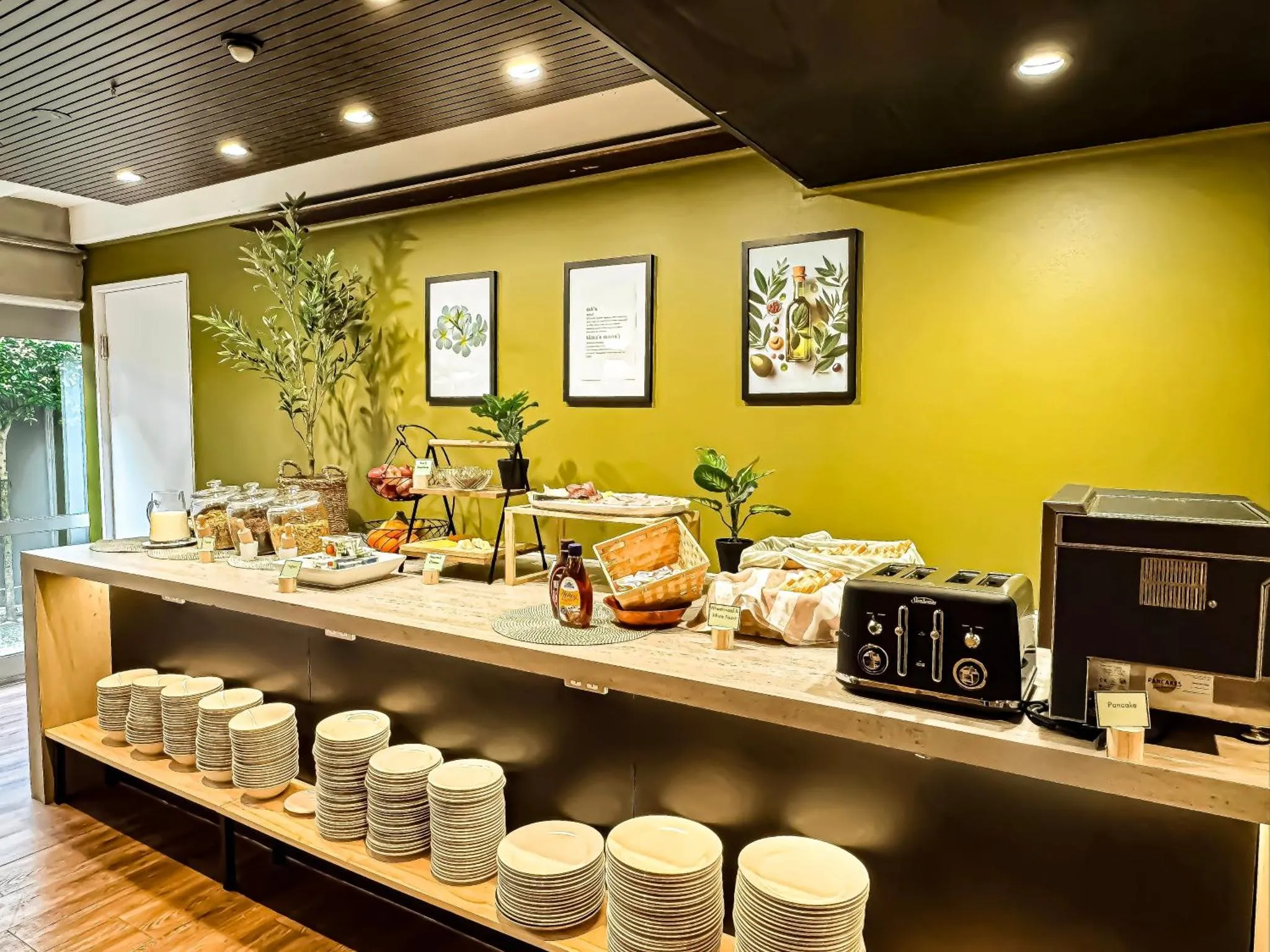 Un buffet propose des pâtisseries, des fruits et des boissons dans une salle lumineuse.