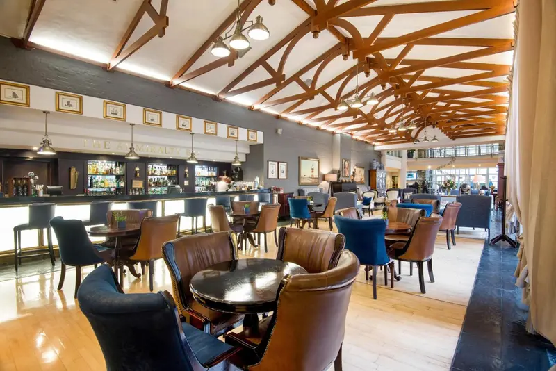 Une salle lumineuse avec un long comptoir de bar et des tables à manger.