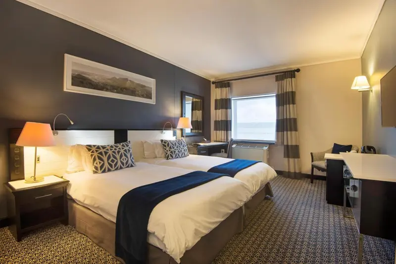 Une chambre d'hôtel lumineuse avec un grand lit et une fenêtre.