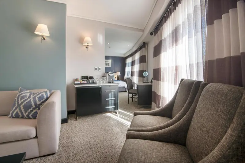 Espace de séjour lumineux avec canapés et bureau.