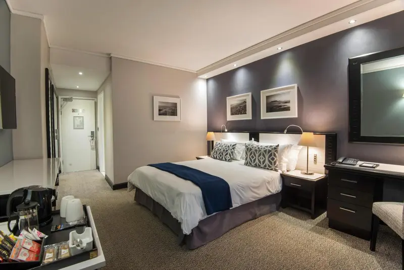 Une chambre d'hôtel moderne avec un grand lit et une décoration sobre.