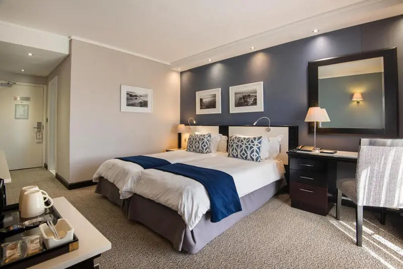 Une chambre d'hôtel lumineuse avec un grand lit et un bureau.