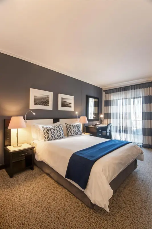 Une chambre d'hôtel moderne avec un grand lit et des œuvres d'art au mur.