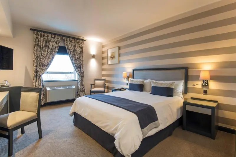 Chambre d'hôtel avec un lit double et un bureau.