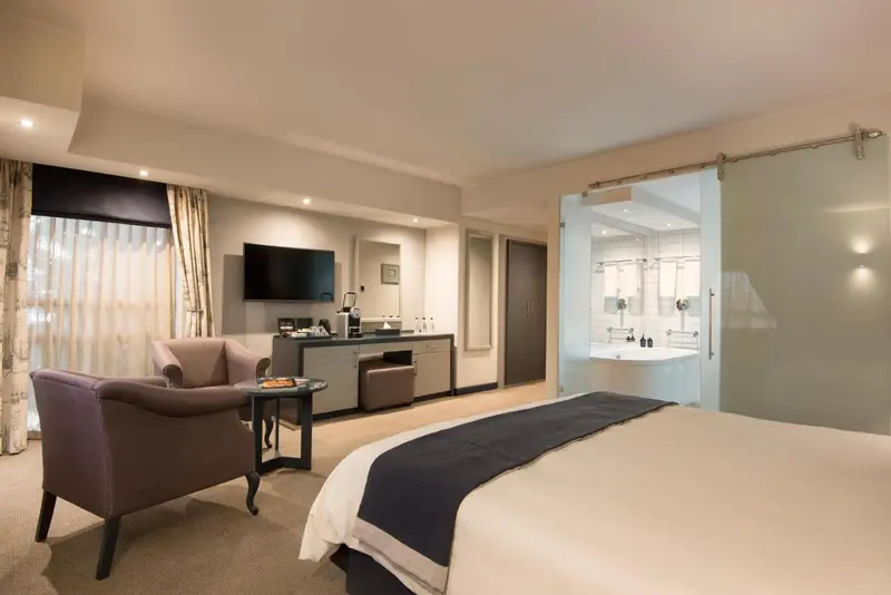 Une chambre lumineuse avec un lit et un coin salon.