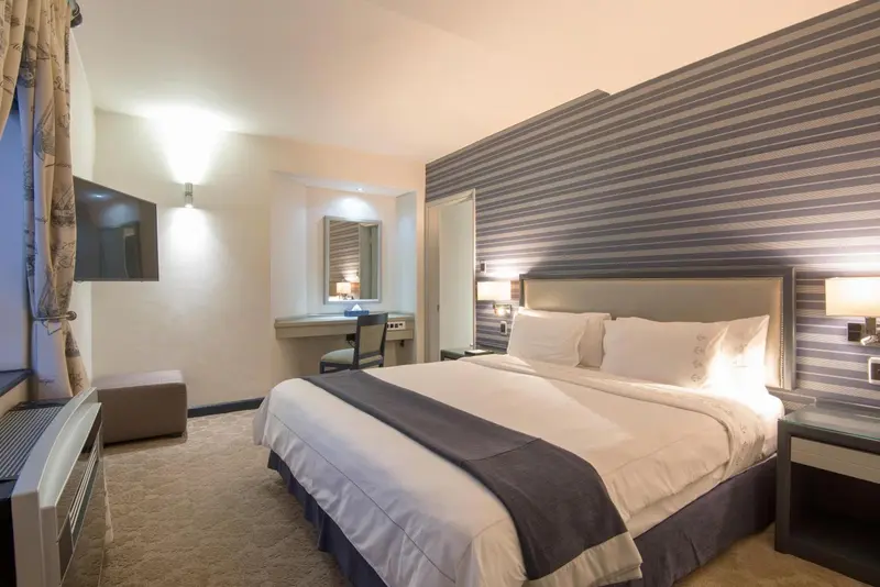 Une chambre d'hôtel lumineuse avec un grand lit et un bureau.