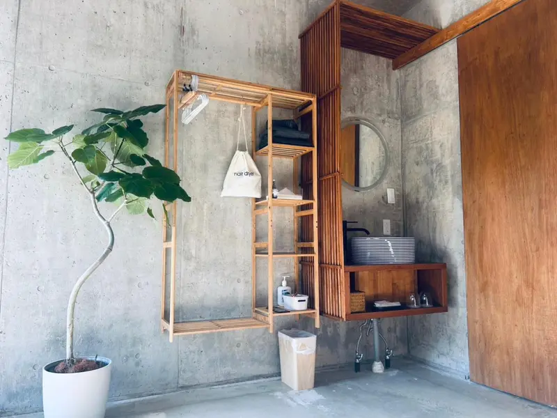 Un espace intérieur minimaliste avec un lavabo et un porte-serviettes en bois.