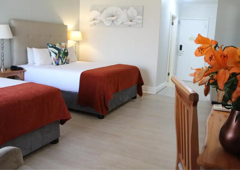 Une chambre lumineuse avec deux lits et une décoration florale.