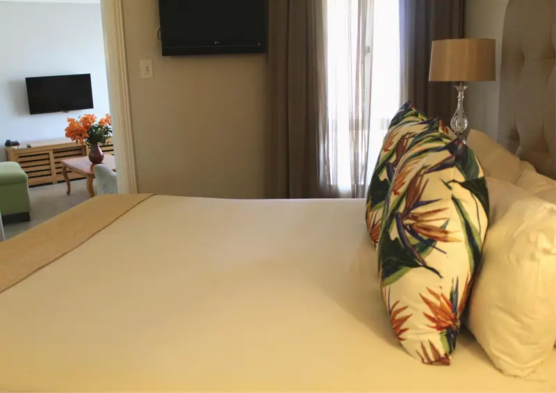 Une chambre lumineuse avec un grand lit et un coin salon.