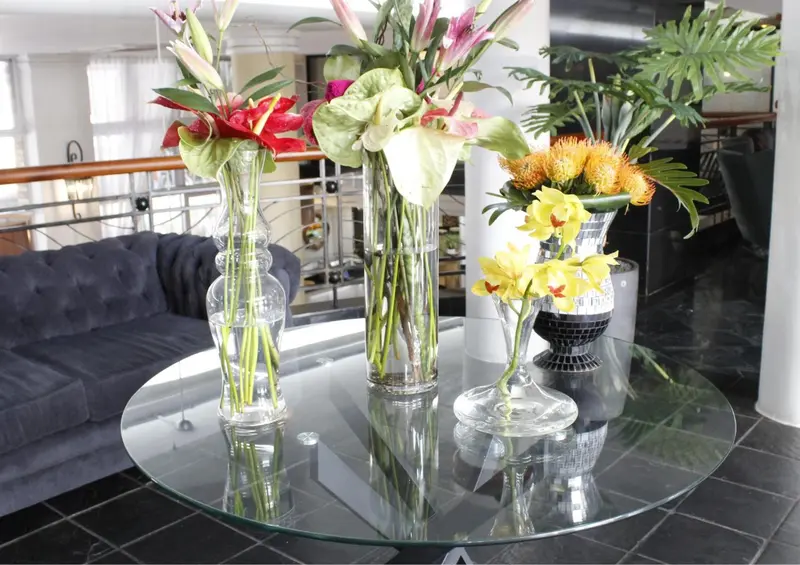 Composition florale colorée sur une table ronde en verre.