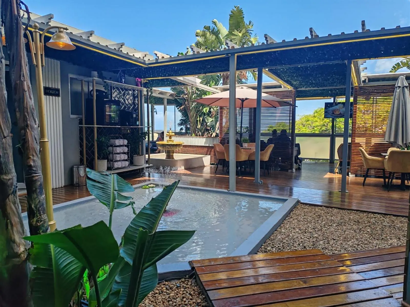 Terrasse ombragée avec mobilier de jardin et petite piscine.