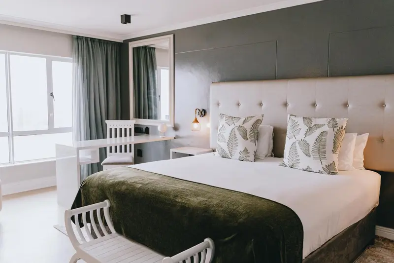 Une chambre lumineuse avec un grand lit et un bureau.
