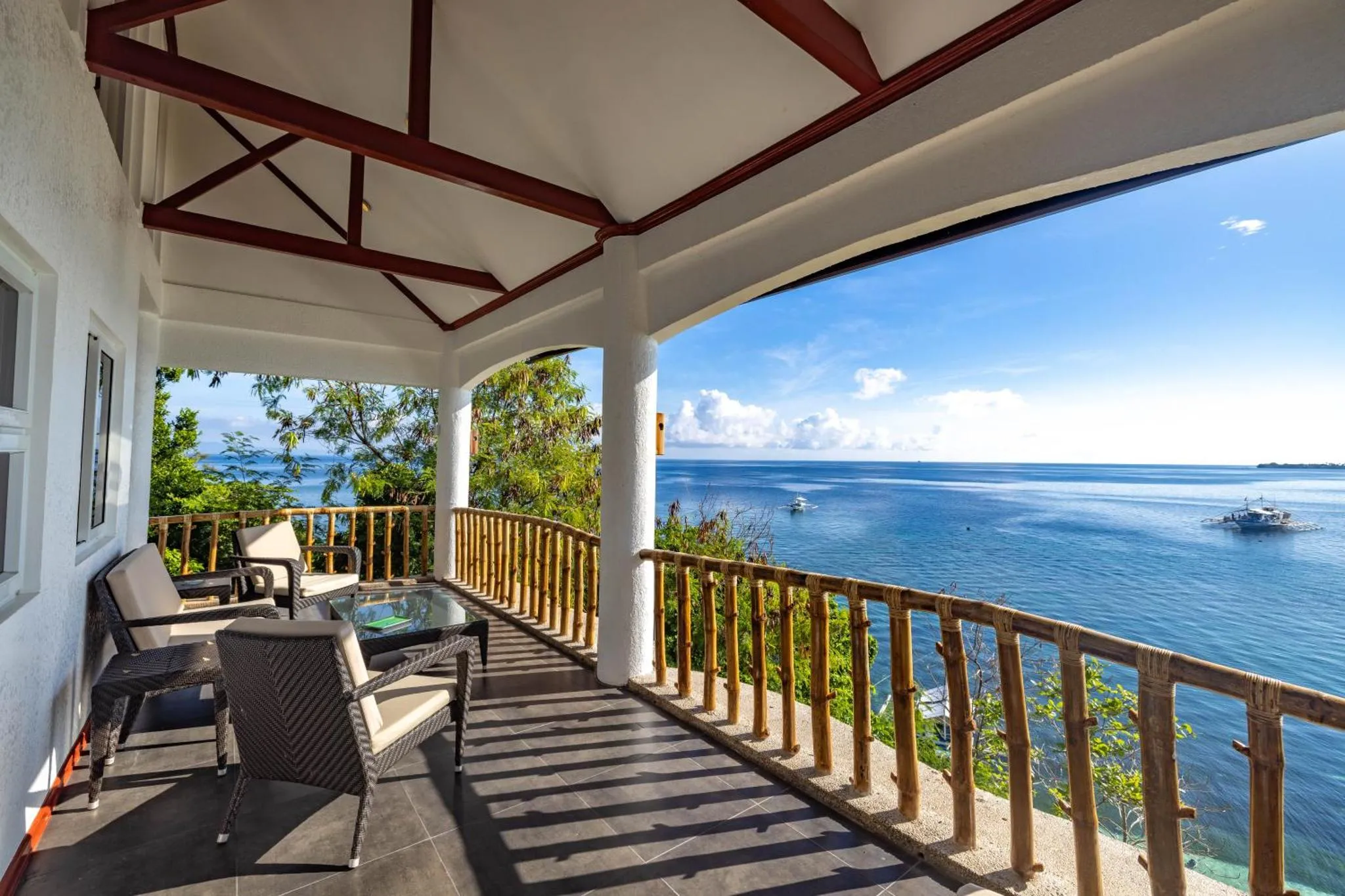 Terrasse ombragée avec mobilier d'extérieur donnant sur la mer.