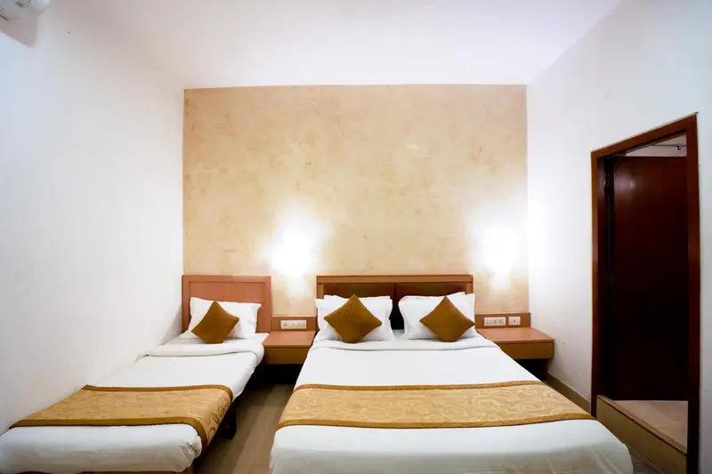 Une chambre avec deux lits simples et une décoration murale claire.