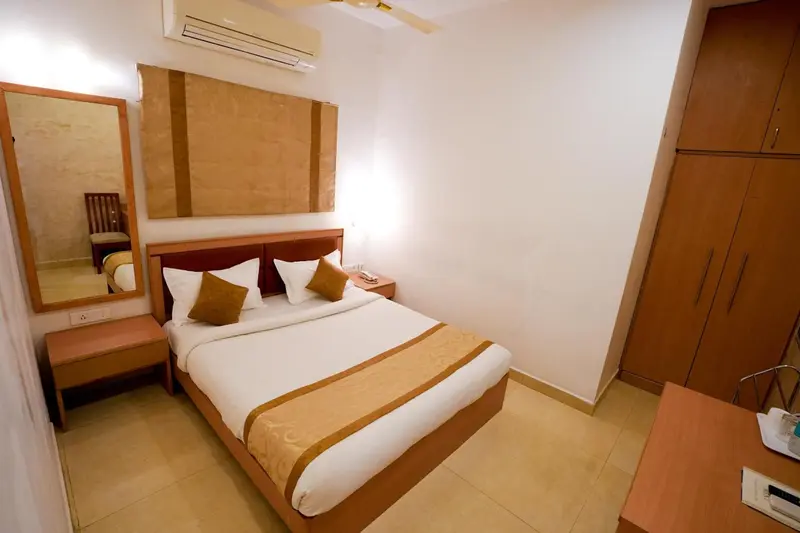 Une chambre lumineuse avec un lit double et un miroir.