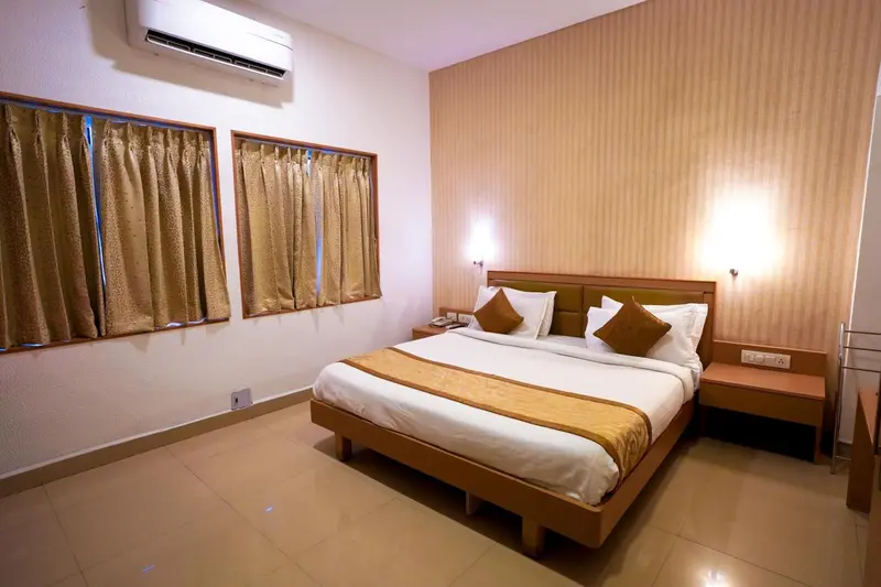 Une chambre lumineuse avec un grand lit et des rideaux décoratifs.