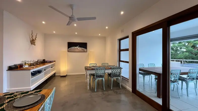 Une salle lumineuse avec une table à manger et un buffet.
