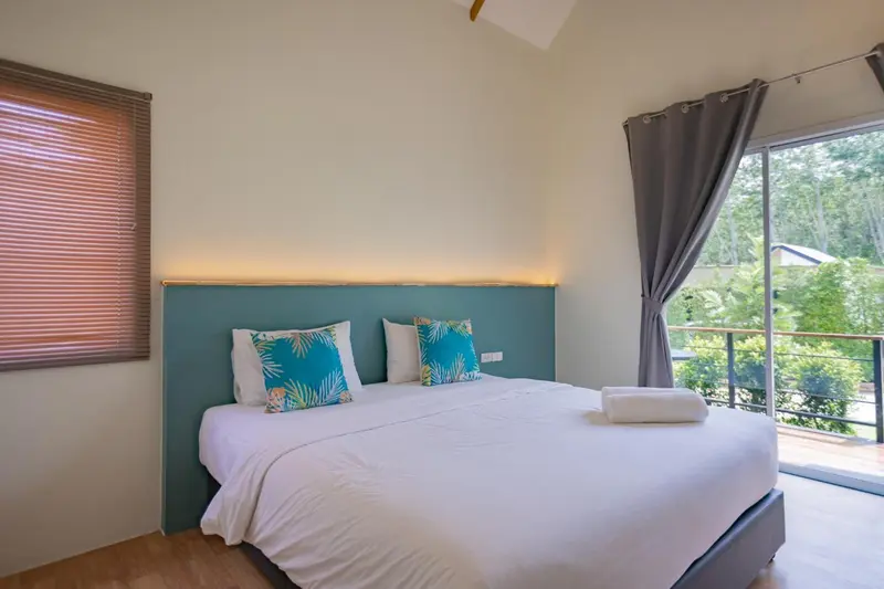 Une chambre lumineuse avec un grand lit et un accès à une terrasse.