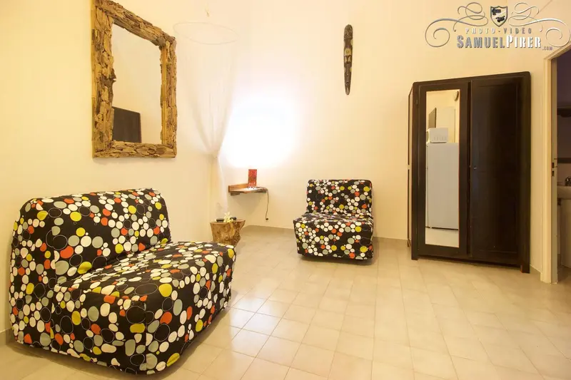 Espace de détente avec deux fauteuils colorés et un grand miroir.