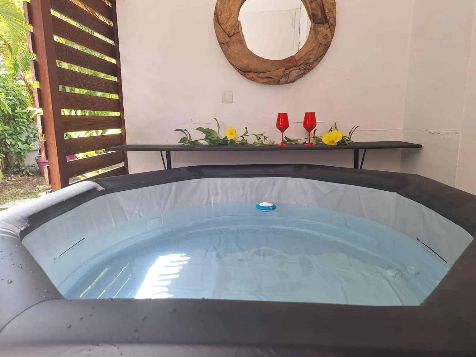 Un jacuzzi extérieur avec une table et des verres.
