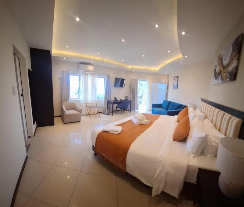 Une chambre lumineuse avec un grand lit et un canapé bleu.