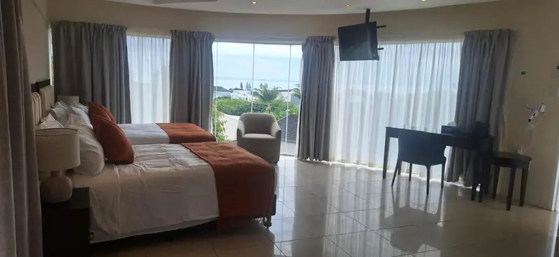 Une chambre lumineuse avec un grand lit et une vue sur la mer.